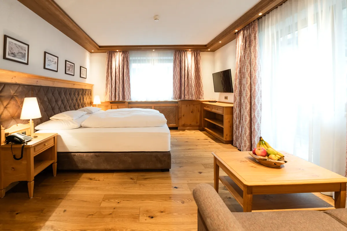 Habitación doble Classic con suelo de madera y zona de estar del Hotel Ulli