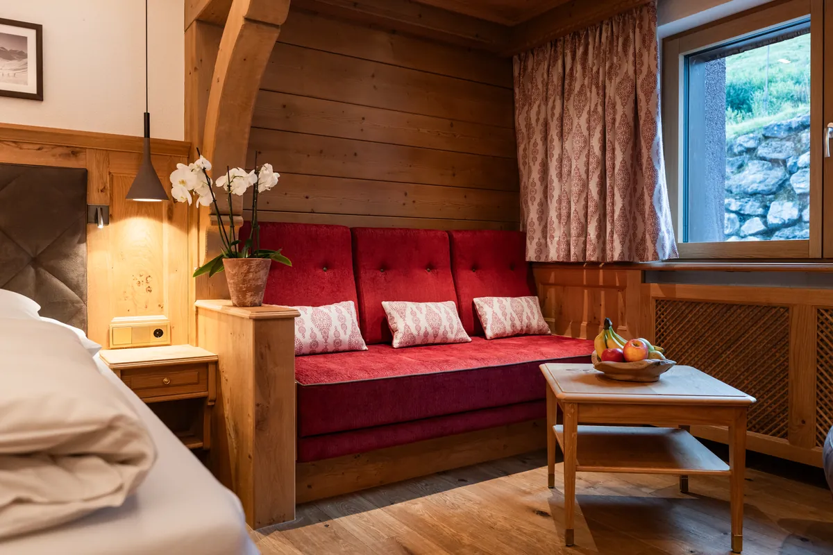 Doppelzimmer Classic mit rotem Sofa und Sitzbereich im Hotel Ulli