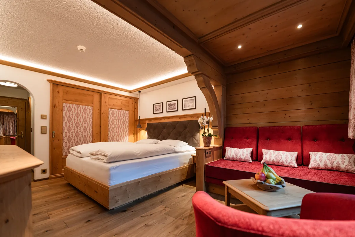 Habitación doble Classic con sofá rojo y techo de madera del Hotel Ulli