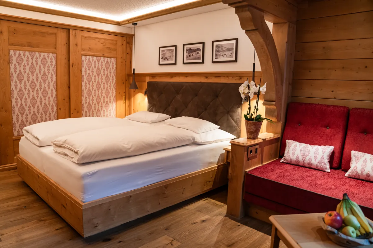 Doppelzimmer Classic mit Doppelbett und rotem Sofa im Hotel Ulli